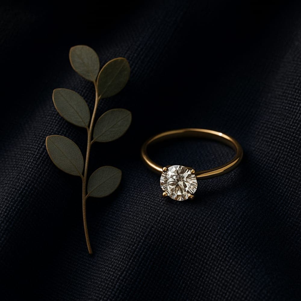 A slim recycled yellow gold band beside a eucalyptus sprig