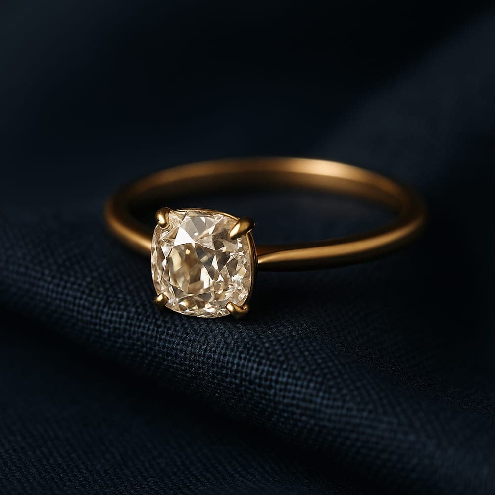 A modern minimalist yellow gold solitaire holding an old-cut diamond