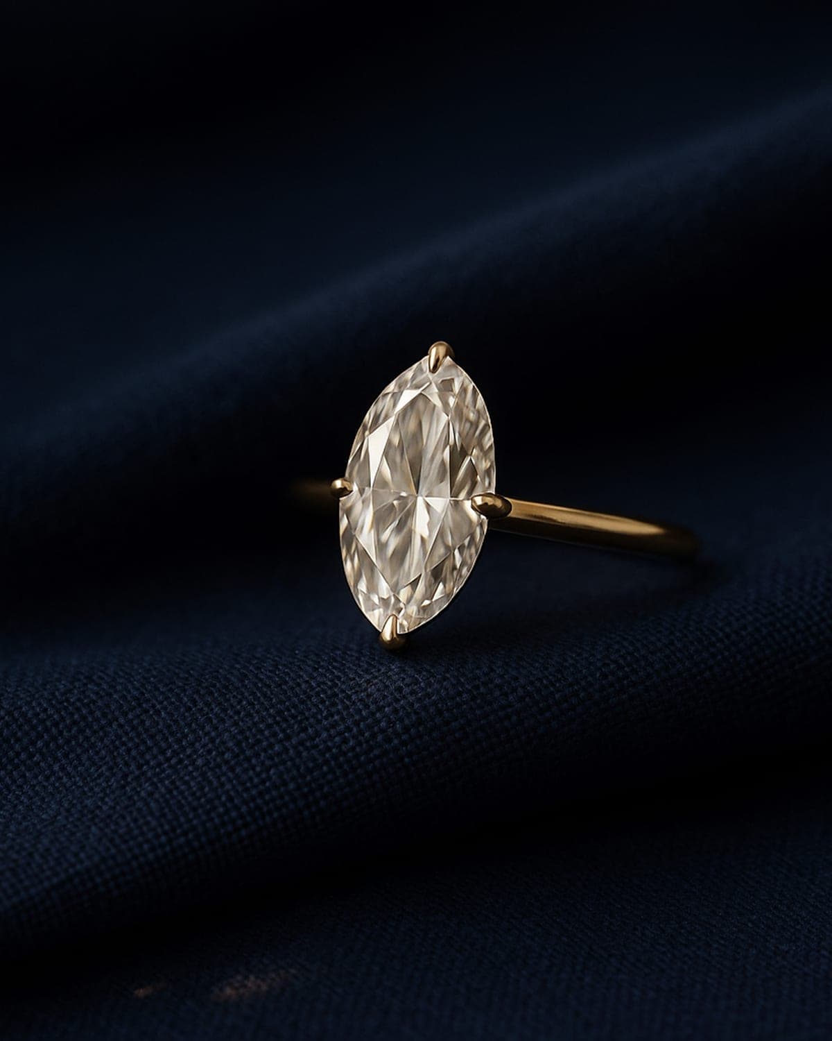 A moval-cut diamond solitaire — an elongated oval with rounded ends — set in yellow gold