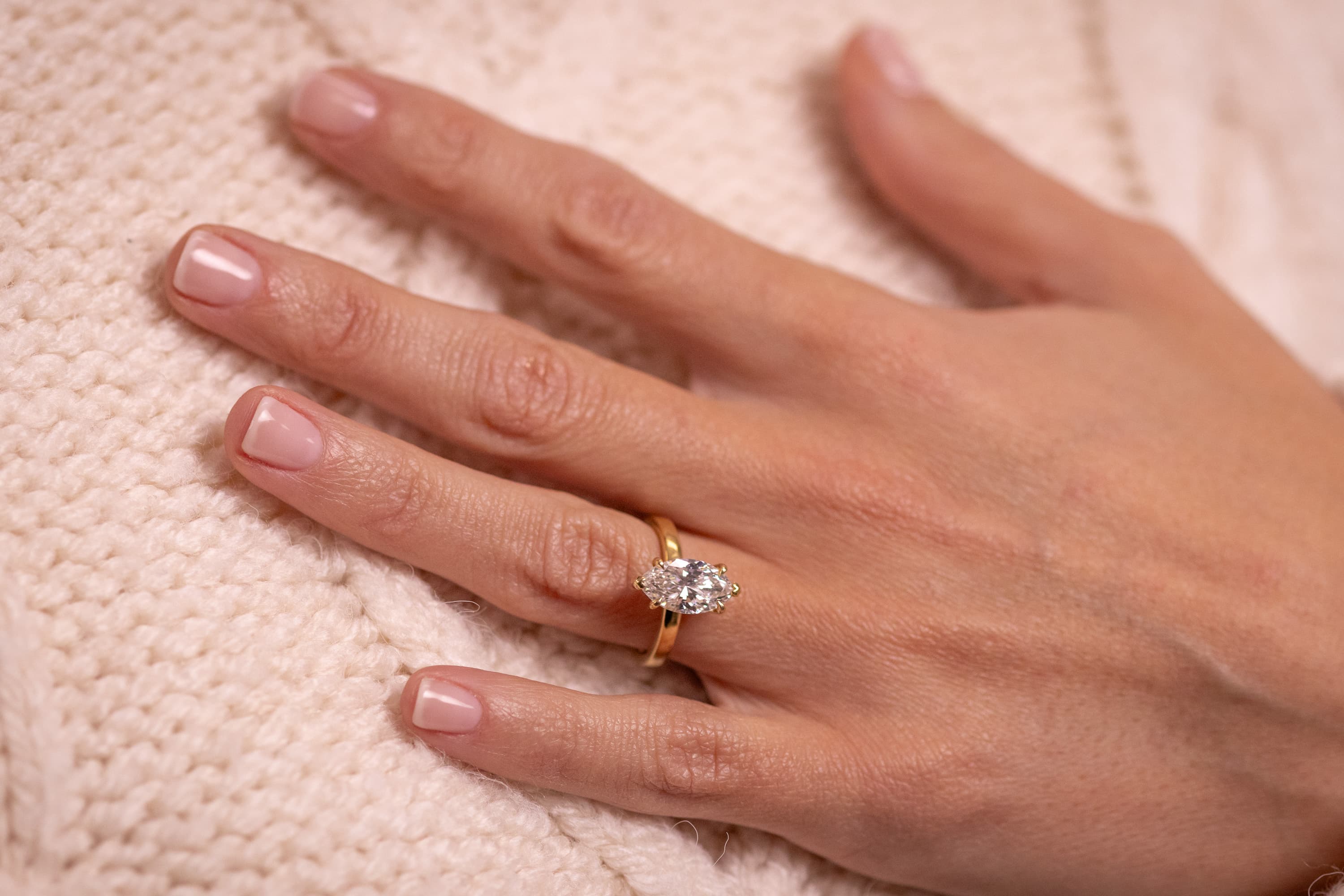 Seven yellow gold engagement rings laid out by setting style — solitaire, halo, hidden halo, bezel, toi et moi, trilogy and east-west
